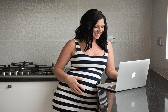Kobieta w zaawansowanej ciąży przed komputerem